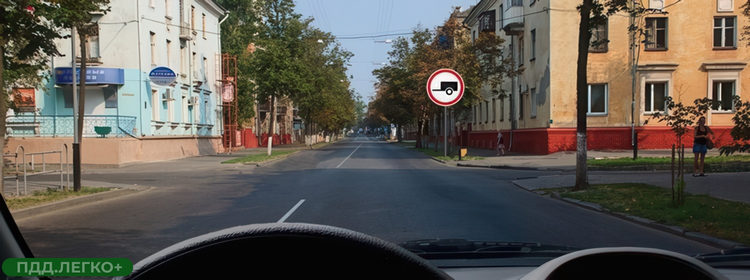 Легковой автомобиль с прицепом перед знаком